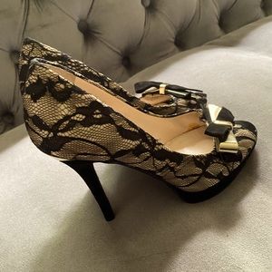 Candies black and ivory lace pumps. Gold and velvet bows near toes.